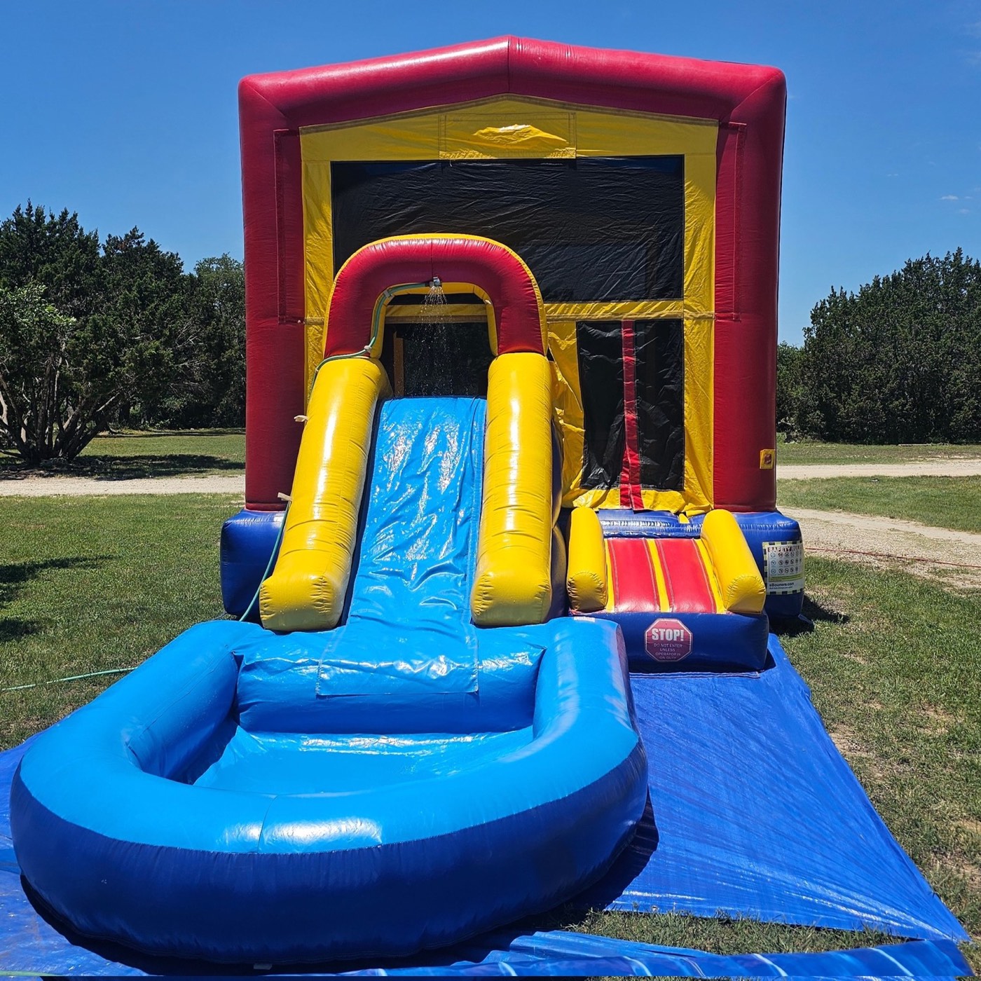 Red yellow and blue bounce house with slide and splash pool