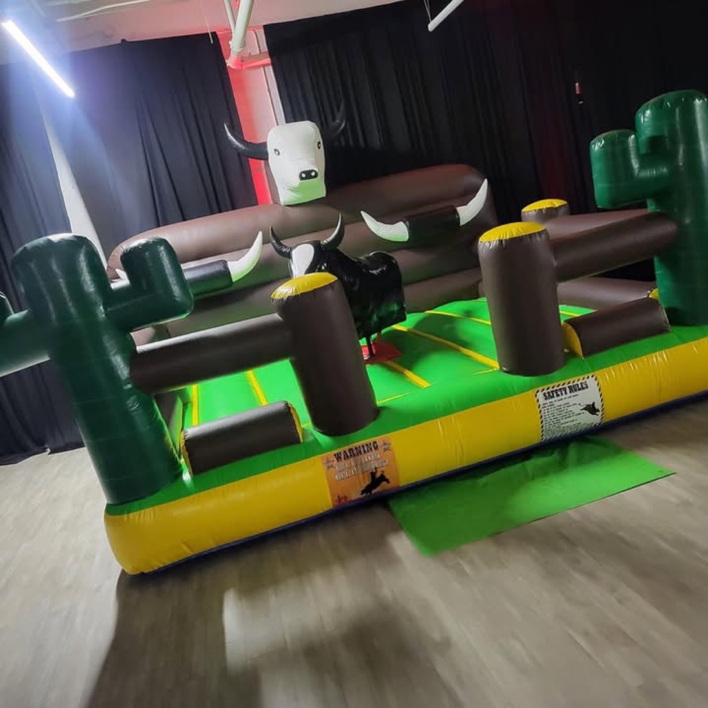 Yellow Wild West themed mechanical bull with cactus corner bumpers